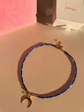 Load image into Gallery viewer, Woman blue and gold beaded necklace with moon pendant
