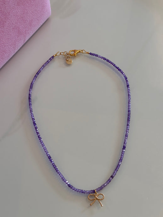Beaded necklace with amethyst and gold plated silver bow pendant
