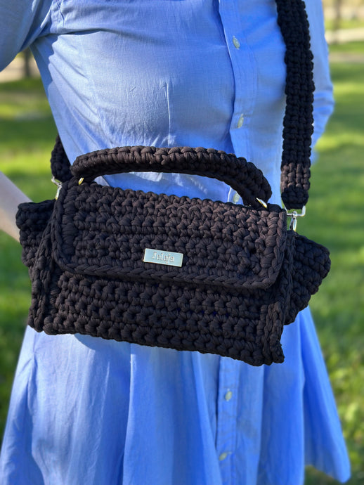 Black crossbody bag with recycled cotton. Worn on a blue shirt dress